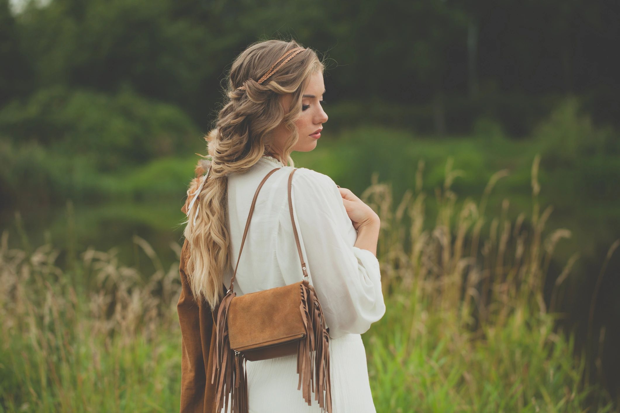 Woman accessorized with a suede handbag and modern outfit