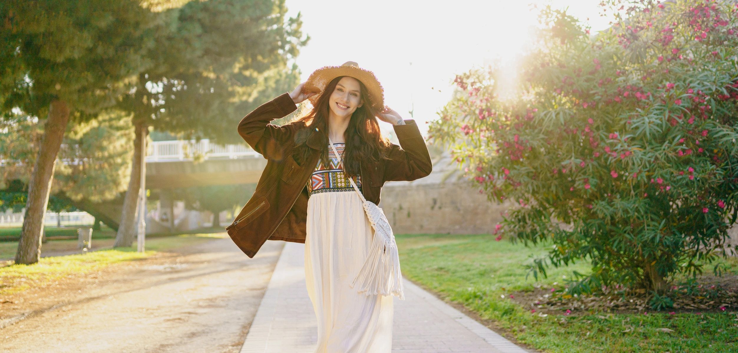 Joyful woman in a stylish hat modeling a flowy dress